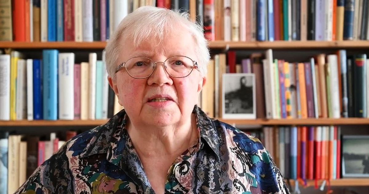 Portraitaufnahme Luise F. Pusch, eine wei&szlig;haarige 75-J&auml;hrige, vor ihrem Regal voller B&uuml;cher